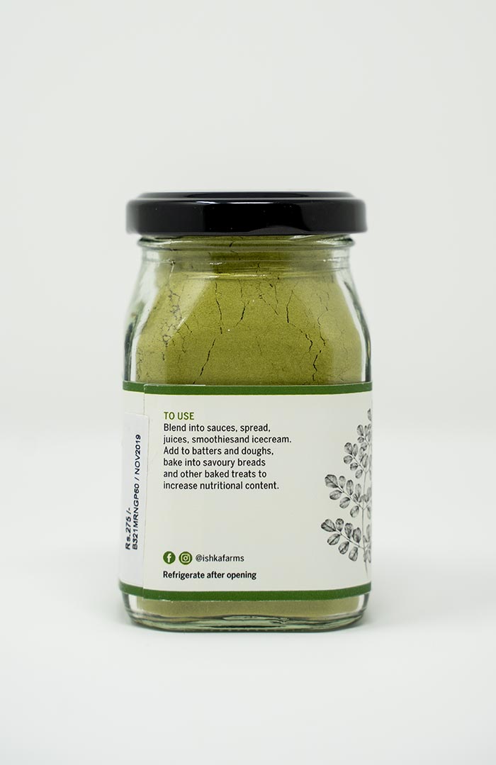 Pure moringa powder in a glass bottle, farm-produced organically by Ishka Farms